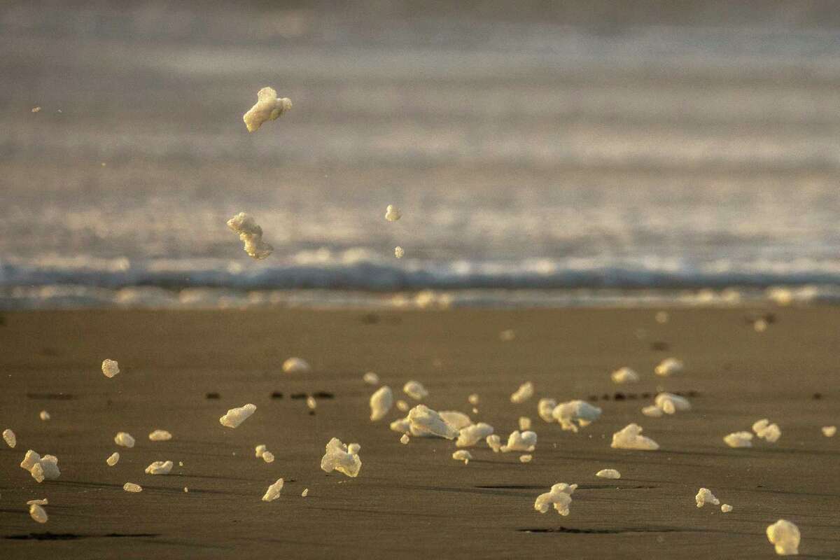 Sea foam blows across Ocean Beach in San Francisco as high winds continue to batter the region. The unusually bitter cold storm has brought hail and even some snow to parts of the Bay Area