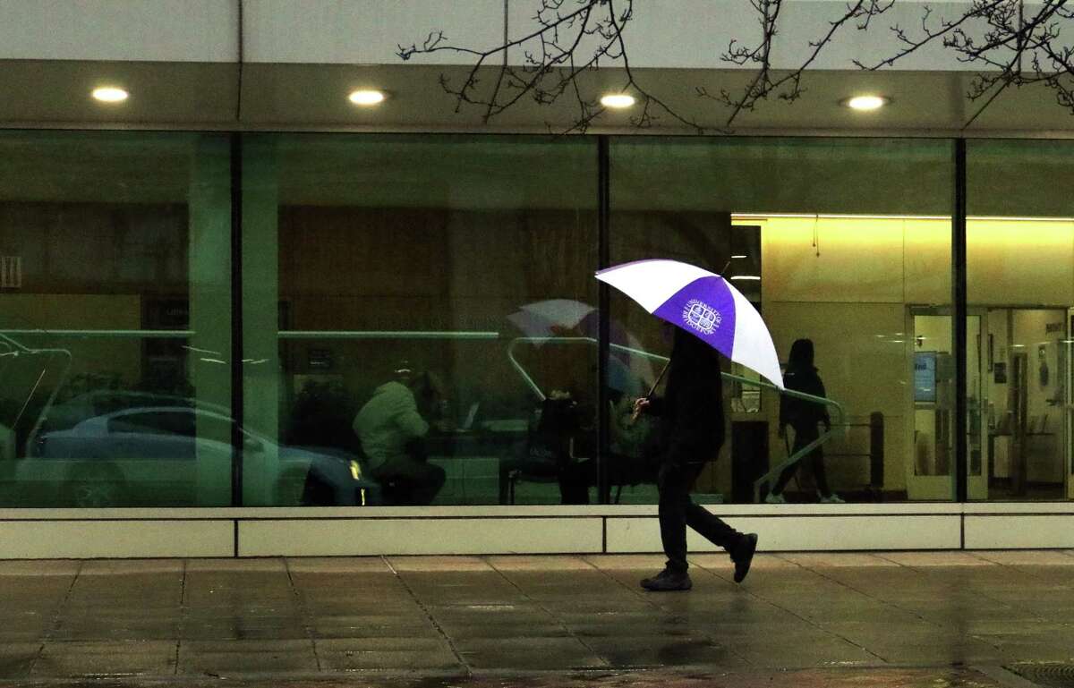 During a light rain, a pedestrian carries an umbrella along Broad Street in Stamford, Conn., on Wednesday February 22, 2023.