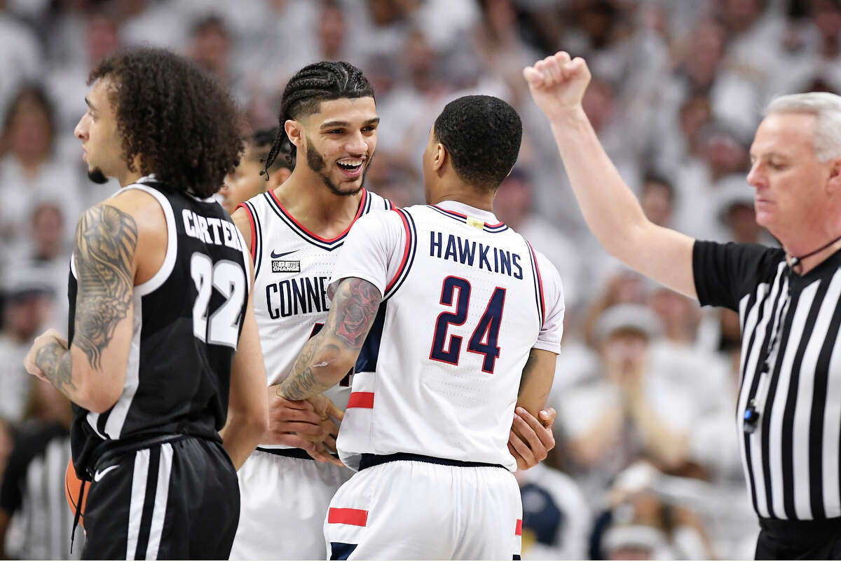 UConn's Andre Jackson Jr., center left, smiles as he grabs teammate Jordan Hawkins after Hawkins fouled Providence's Devin Carter, left, during the second half of an NCAA college basketball game Wednesday, Feb. 22, 2023, in Storrs, Conn. (AP Photo/Jessica Hill)