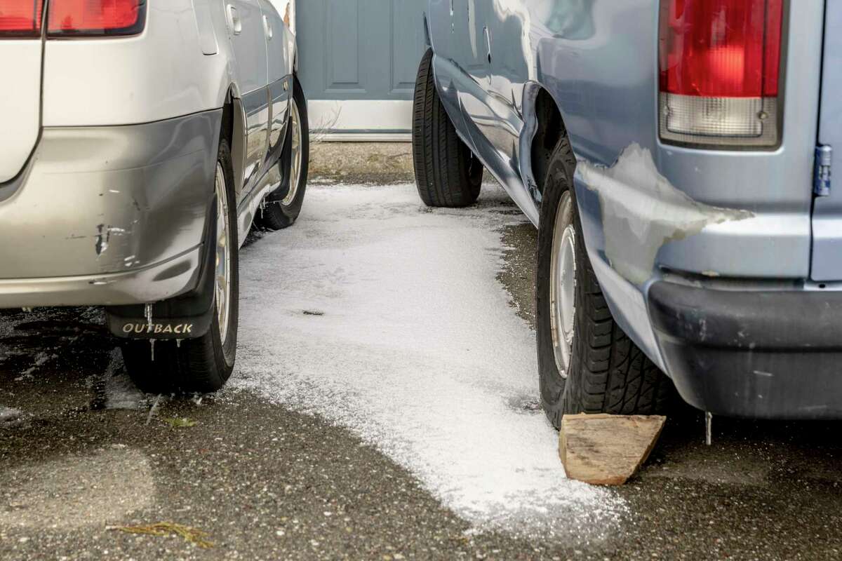 A rare layer of snow and ice is seen between two parked vehicles on Mount Hamilton in Santa Clara County.