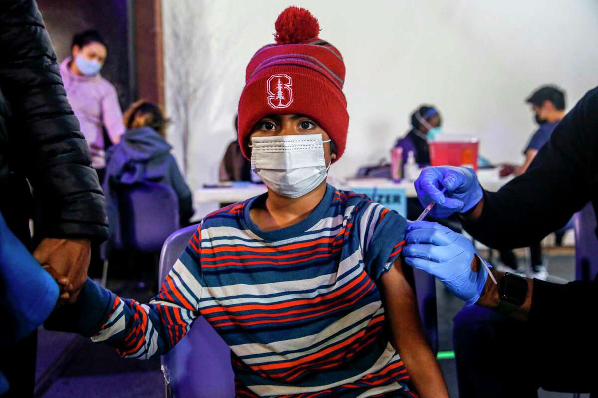 2022年1月2日，9岁的卡纳夫·纳德卡尼在圣克拉拉县公共卫生部在圣何塞儿童探索博物馆举办的疫苗接种诊所接受辉瑞疫苗。