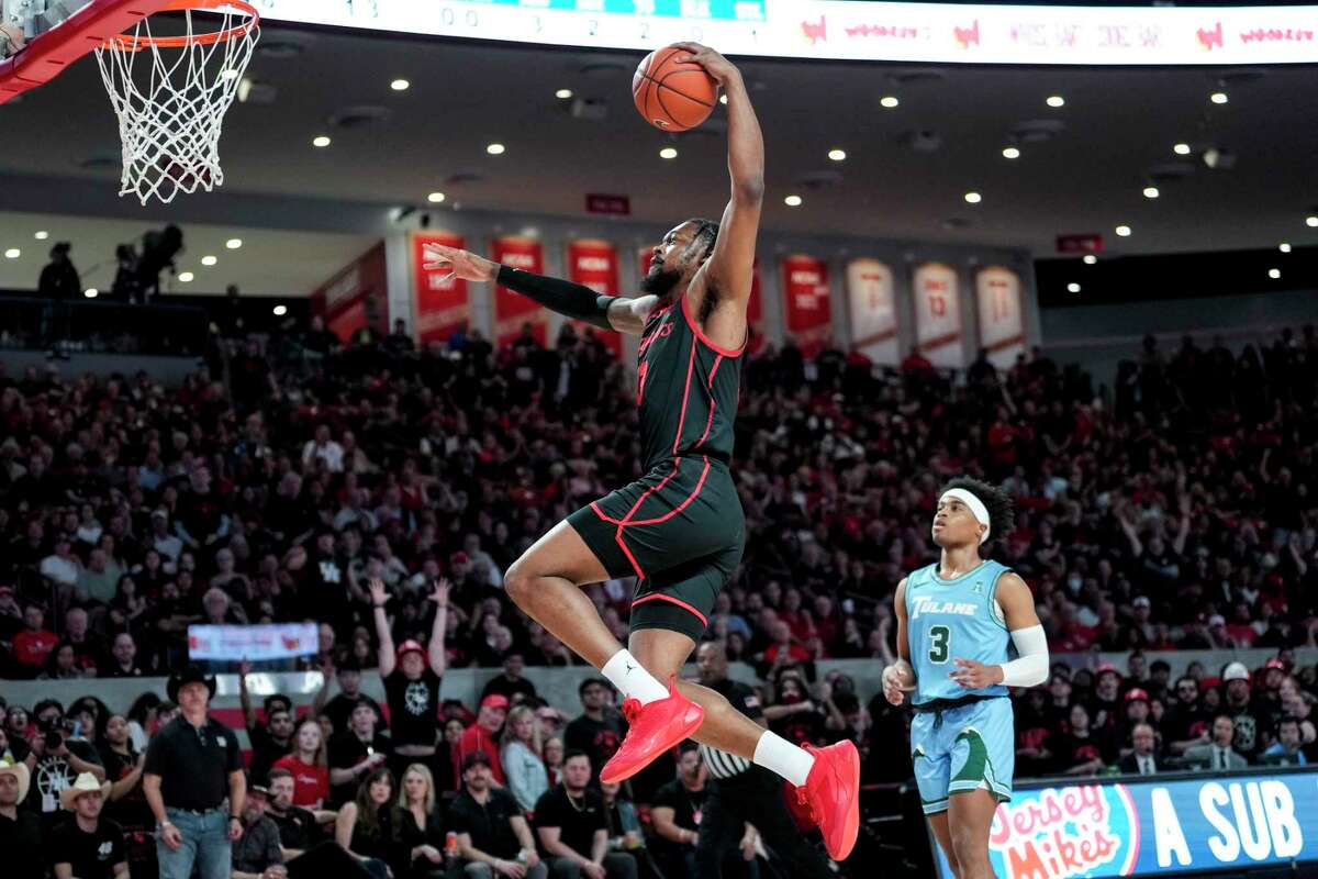Houston forward J'Wan Roberts (13) goes up for a dunk as he runs past Tulane guard Jalen Cook (3) on a fast break during the first half of an NCAA college basketball game Wednesday, Feb. 22, 2023, in Houston.