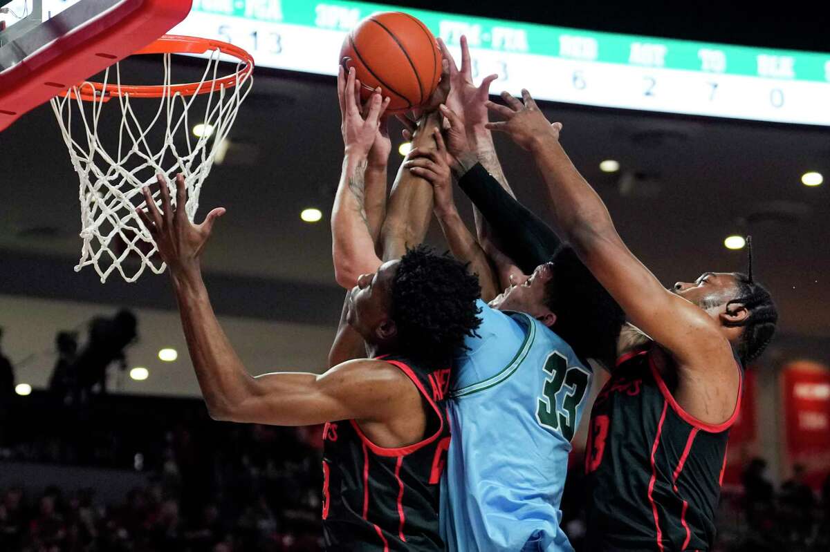 Houston guard Terrance Arceneaux (23) and forward J'Wan Roberts (13) go up for a rebound against Tulane forward Tylan Pope (33) during the first half of an NCAA college basketball game Wednesday, Feb. 22, 2023, in Houston. Robert was called for a foul on the play.