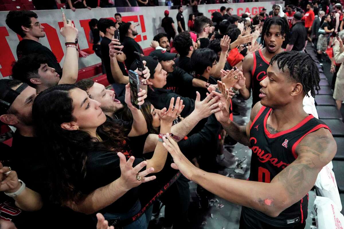 Houston guard Marcus Sasser (0) high fives through the student section after an 89-59 win over Tulane in an NCAA college basketball game Wednesday, Feb. 22, 2023, in Houston.