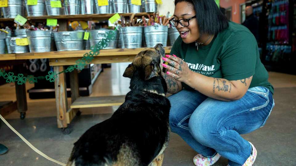 Natural Pawz employee Taralynn Smith greets a pup at the Natural Pawz location on Washington Ave. on Wednesday, Feb. 22, 2023.