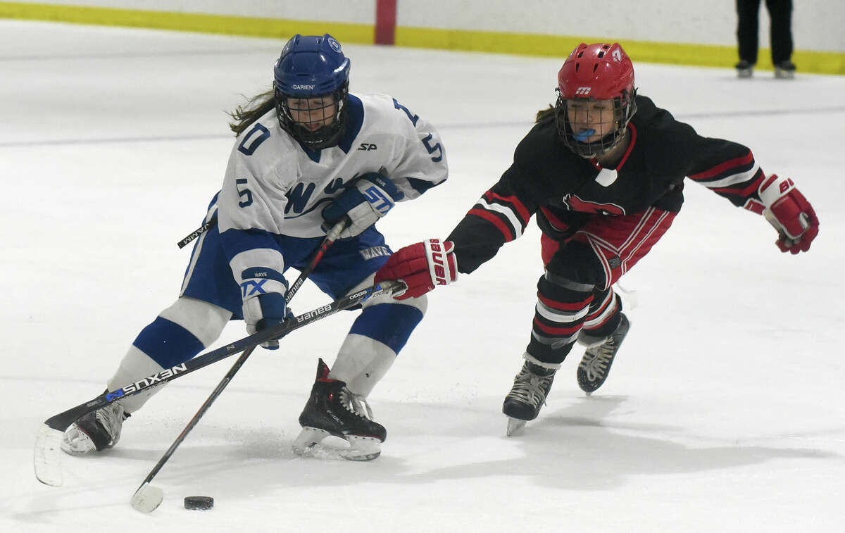 Darien's Maggie Bellissimo (5) looks shoot while Greenwich's Lexi Carino (14) defends during the FCIAC girls ice hockey semifinals at the Darien Ice House on Wednesday, Feb. 22, 2023.