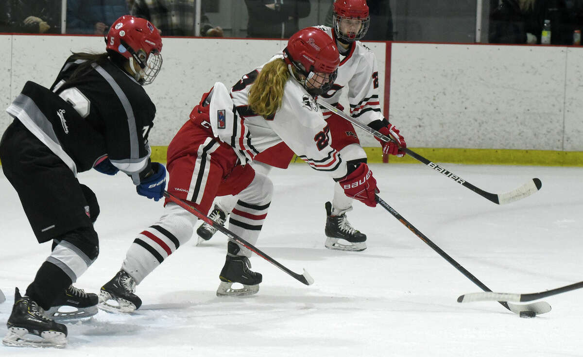 New Canaan's Serena O'Connor (27) reaches for the puck against Stamford/Westhill/Staples during the FCIAC girls ice hockey semifinals at the Darien Ice House on Wednesday, Feb. 22, 2023.
