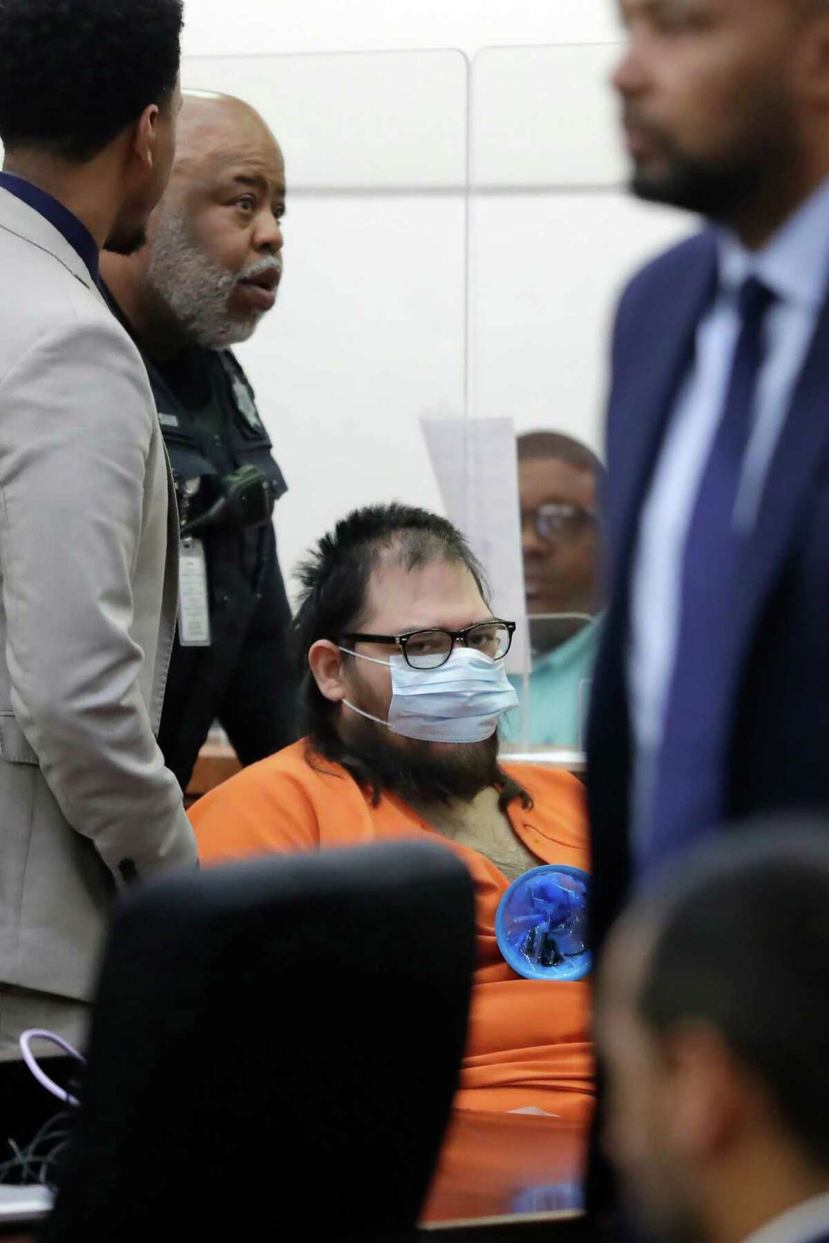 Hayim Cohen, in orange, is wheeled out of the courtroom by baliffs after his arraignment in the 182nd District courtroom in the Criminal Courthouse Thursday, Feb. 23, 2023 in Houston.