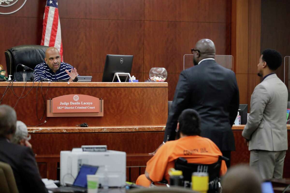 Hayim Cohen, in orange, listens as Judge Danilo Lacayo, left, explains procedures to defense attorneys Charles Johnson and Eddy Tecle, right, as Cohen is arraigned in the 182nd District courtroom in the Criminal Courthouse Thursday, Feb. 23, 2023 in Houston.