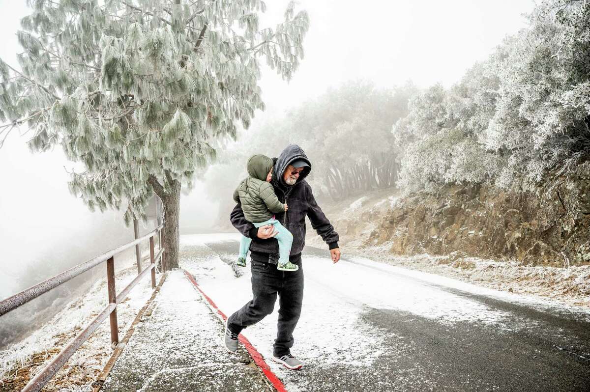 Terry Greenaway and grandson Julian Greenaway, 2, frolic in frosty weather at the summit of Mount Diablo  in Contra Costa County.