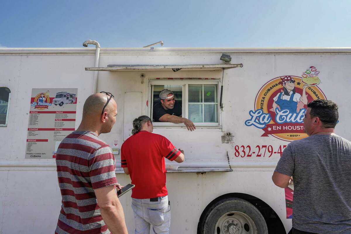 Owner of La Cubana Food Truck, Yasser Del Valle Hernandez, takes orders from regulars who are mostly cuban truck drivers on Thursday, Feb. 23, 2023 in Houston. “ People come here because of the quality of food but also the service.” He said.