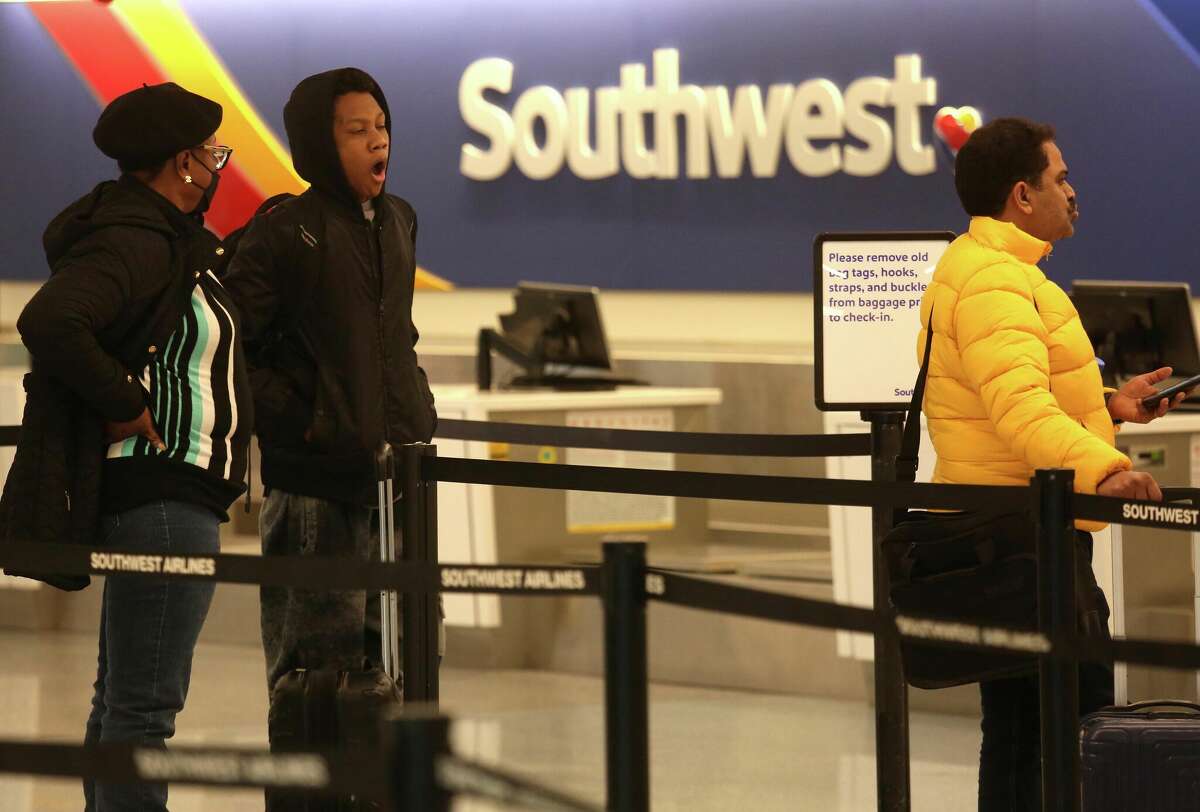 A passenger yawns while waiting in a very short line to check in at Southwest Airlines on Dec. 9, 2022.