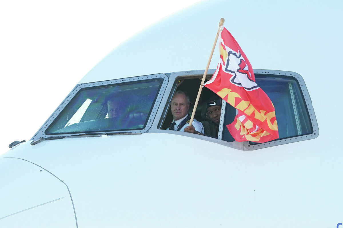 Carlos Dunlap of the Kansas City Chiefs waves a flag as the team arrives at Kansas City International Airport on Feb. 13, 2023, in Kansas City, Missouri.
