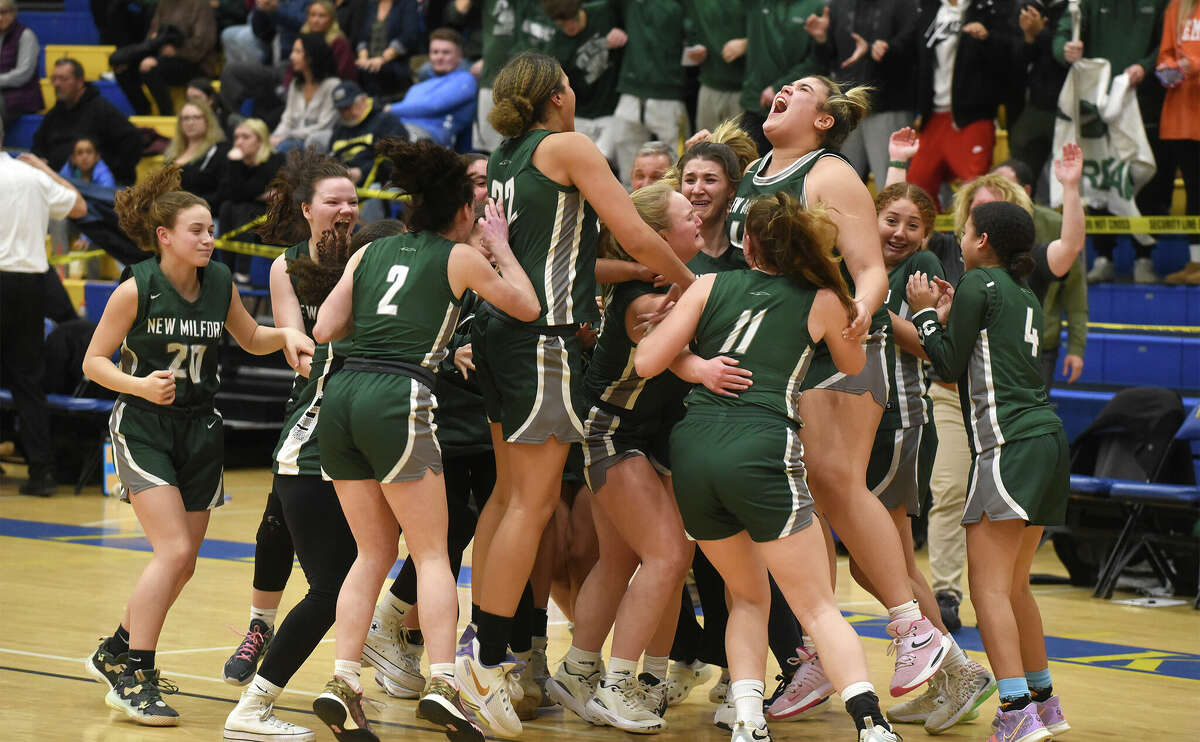 New Milford girls basketball players celebrate after defeating Immaculate for the SWC girls basketball championship in Newtown on Thursday, Feb. 23, 2023.