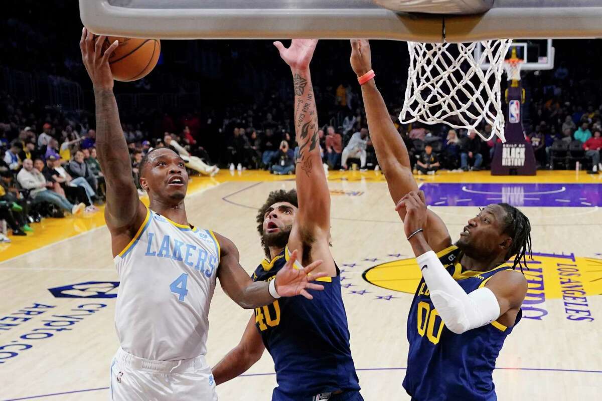 Los Angeles Lakers guard Lonnie Walker IV, left, shoots as Golden State Warriors forward Anthony Lamb, center, and forward Jonathan Kuminga defend during the second half of an NBA basketball game Thursday, Feb. 23, 2023, in Los Angeles. (AP Photo/Mark J. Terrill)