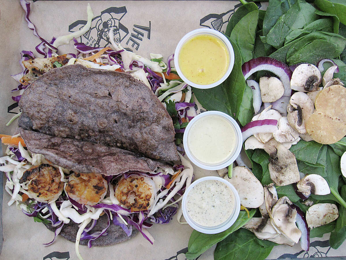 The Seafood Sampler is a grilled fish taco and a grilled shrimp taco with a baby spinach salad at The Cove, one of 10 places to get good fish tacos for Lent in San Antonio.