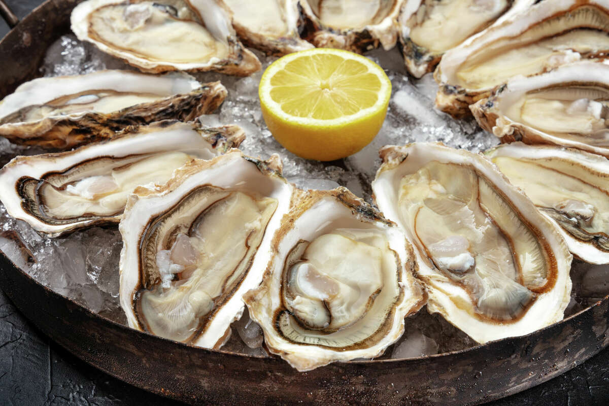 Raw oysters from Canada could be contaminated with the norovirus. The FDA says restaurants, retailers and consumers should avoid them. IMAGE: Oysters close-up. A dozen of raw oysters on a platter, with lemon