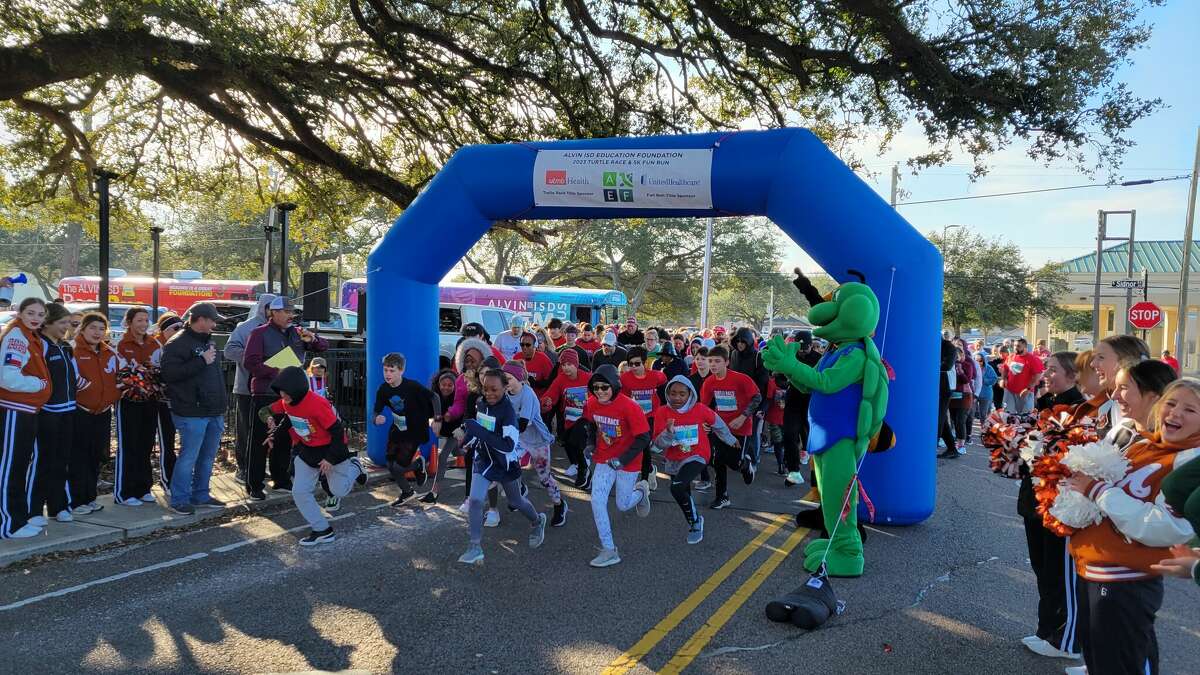 Alvin ISD Education Foundation's turtle mascot cheers as runners start on a run that was part of the annual Turtle Race.  