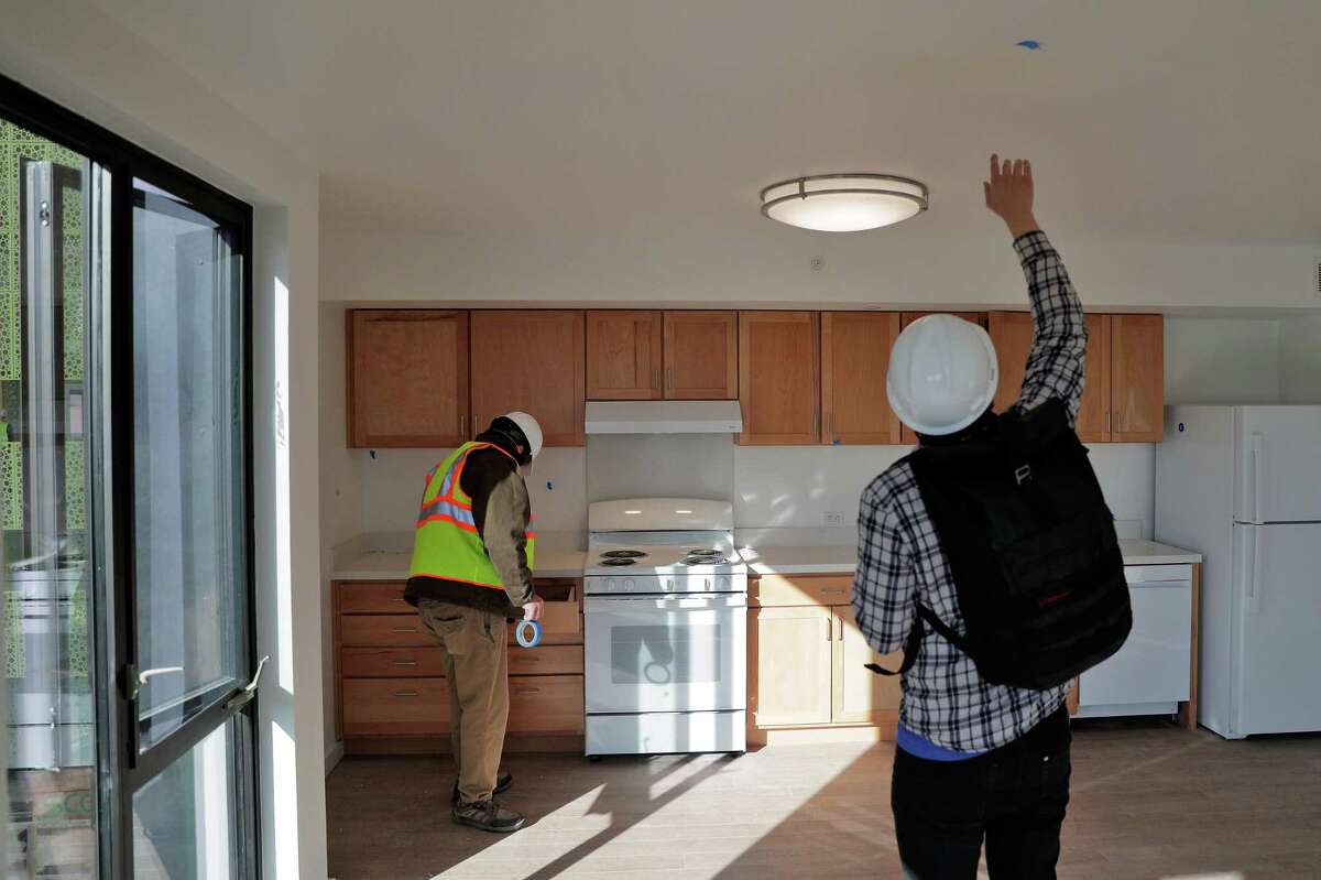 Gregory Gordon and Tony Li work at the Casa Adelante apartments in December 2020 in San Francisco, where natural gas is banned in new construction. 