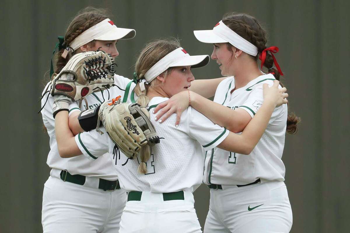 The Woodlands left fielder Avery Vasel (4) gathers alongside center fielder Gabby Leach (10) and right fielder Alannah Leach (1) before the start of the third inning of a non-district high school softball game at The Woodlands High School, Friday, Feb. 24, 2023, in The Woodlands.