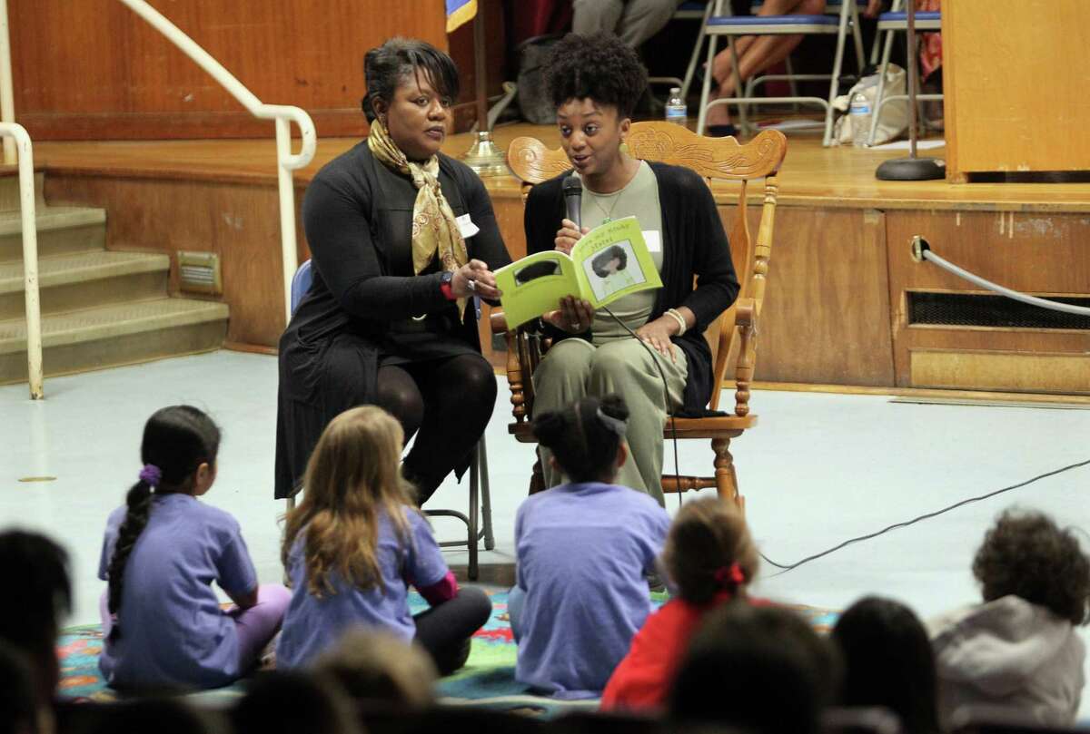 Author Nadene McKenzie-Reid, left, and her daughter and illustrator Carlee Reid, do a reading of their book "I Love My Kinky Hair" during a Book Giveaway event with books that focus on Black and Latino American stories at Roxbury Elementary School in Stamford, Conn., on Friday February 24, 2023. Stamford Public Schools provided every K-3 school in Stamford with the books with funding coming from the Connecticut General Assembly.