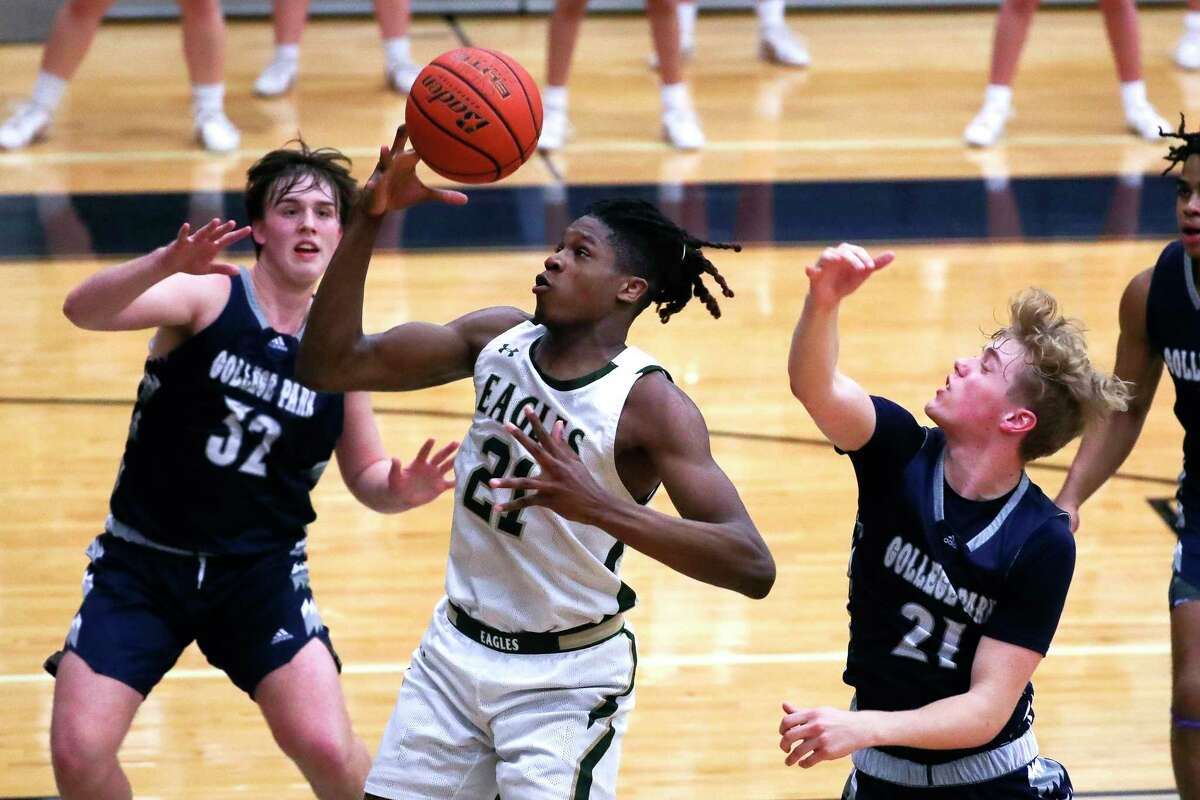 Cypress Falls' Joseph Tugler (21) bobbles a pass in the paint between College Park's Zane Cooper (32) and Evan Mason (21) during the third quarter of a Region II-6A area high school playoff game at Tomball Memorial High School, Friday, Feb. 24, 2023, in Tomball.