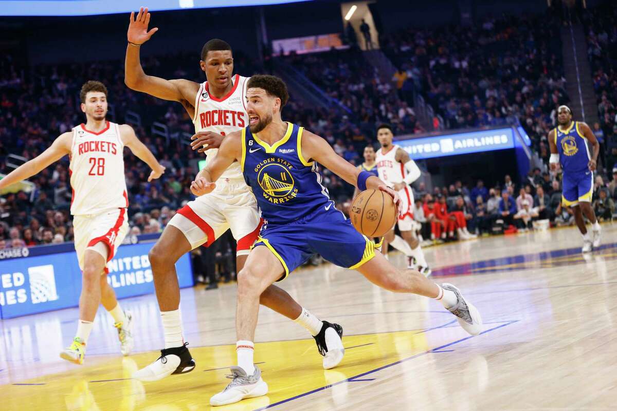 Warriors guard Klay Thompson drives around Rockets forward Jabari Smith Jr. in the first quarter of Golden State's win over Houston on Friday.