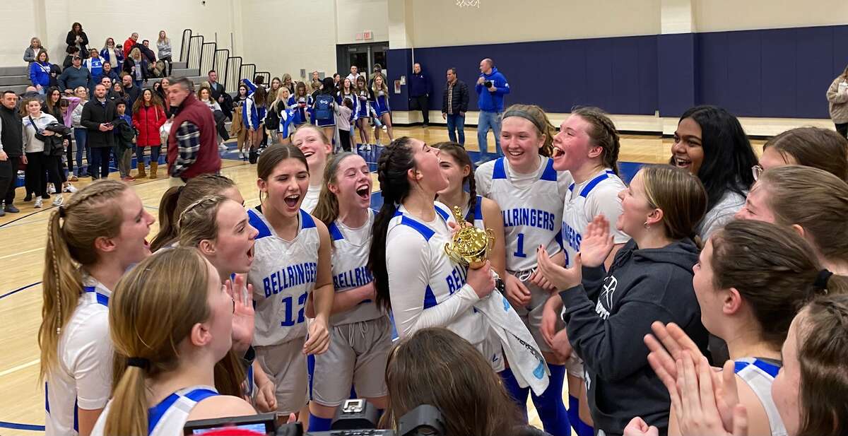 Members of the East Hampton girls basketball team celebrate after defeating Cromwell for the program's fourth-straight Shoreline Conference title on Friday.