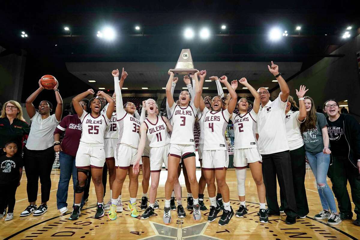 Pearland guard Nyah Hardy (3) lifts the champions’ trophy with teammates as they celebrate the team's win over Pearland in the Region III-6A final high school basketball playoff game, Saturday, Feb. 25, 2023, in Houston.