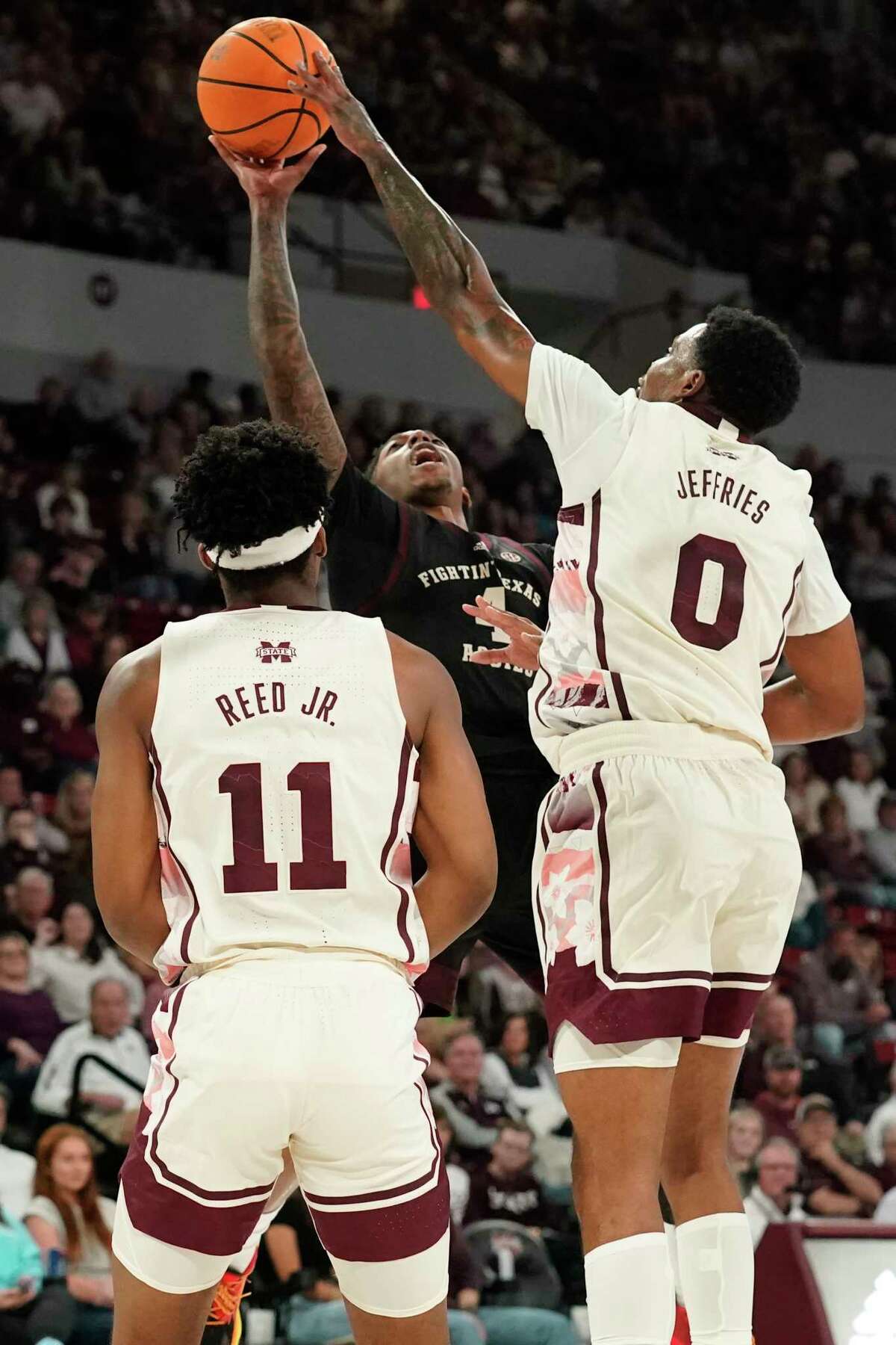 Texas A&M guard Wade Taylor IV (4) has his shot blocked by Mississippi State forward D.J. Jeffries (0) during the first half of an NCAA college basketball game in Starkville, Miss., Saturday, Feb. 25, 2023. (AP Photo/Rogelio V. Solis)