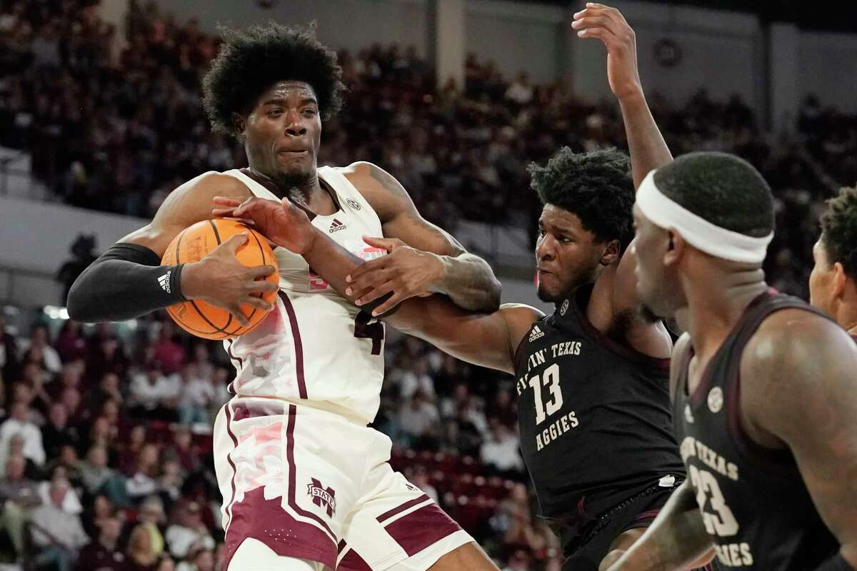 Mississippi State guard Cameron Matthews (4) fights off a steal attempt by Texas A&M forward Solomon Washington (13) during the first half of an NCAA college basketball game in Starkville, Miss., Saturday, Feb. 25, 2023. (AP Photo/Rogelio V. Solis)