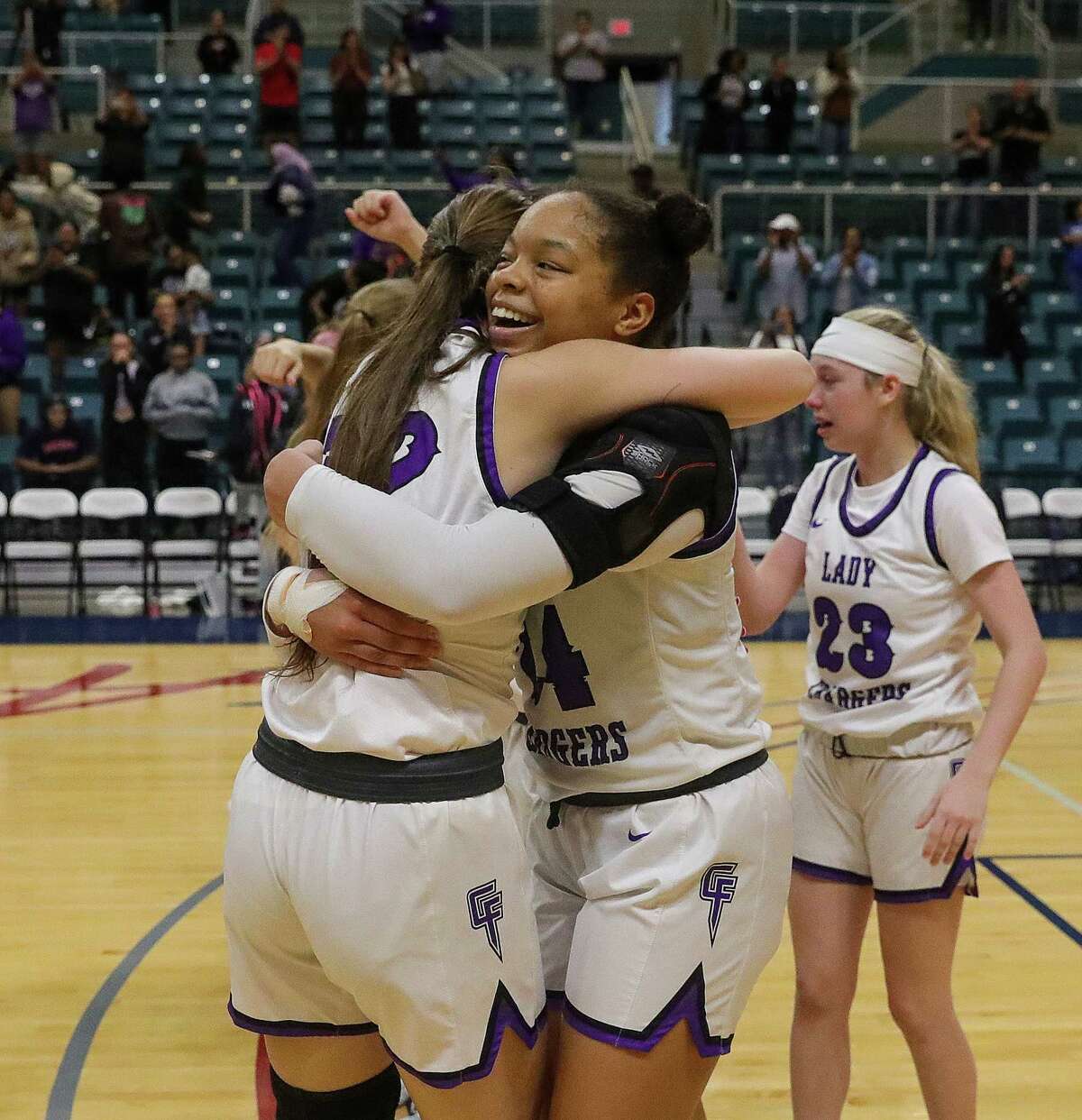 KATY, TX -FEBRUARY 25:Kimora Lopez (24) of Fulshear Chargers of the Fulshear Chargers gives her teammate a hug after winning the Region III-6A championship girls basketball playoff game February 25, 2023 in Katy,Texas.