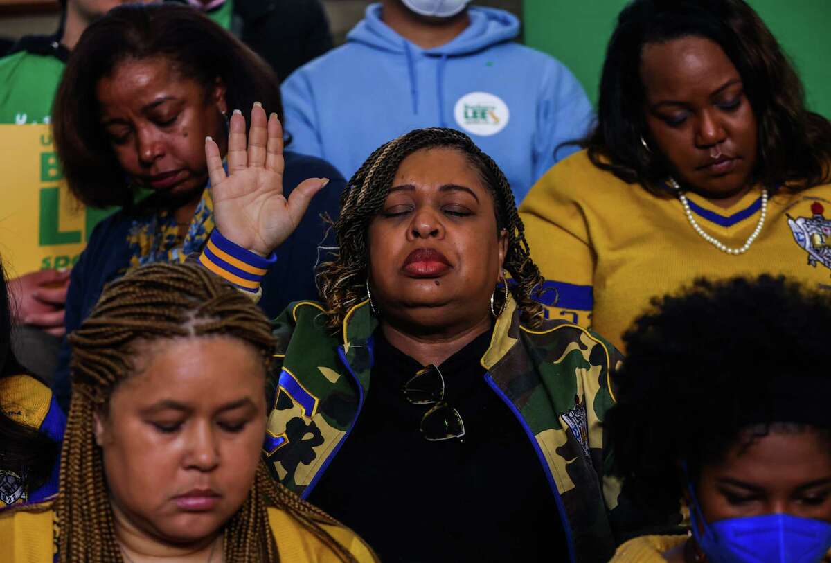 Sonya Simpson raises her hand in prayer during Rep. Barbara Lee's public kickoff event of her Senate campaign at Laney College in Oakland on Saturday. Simpson belongs to Sigma Gamma Rho, the same sorority as Lee.