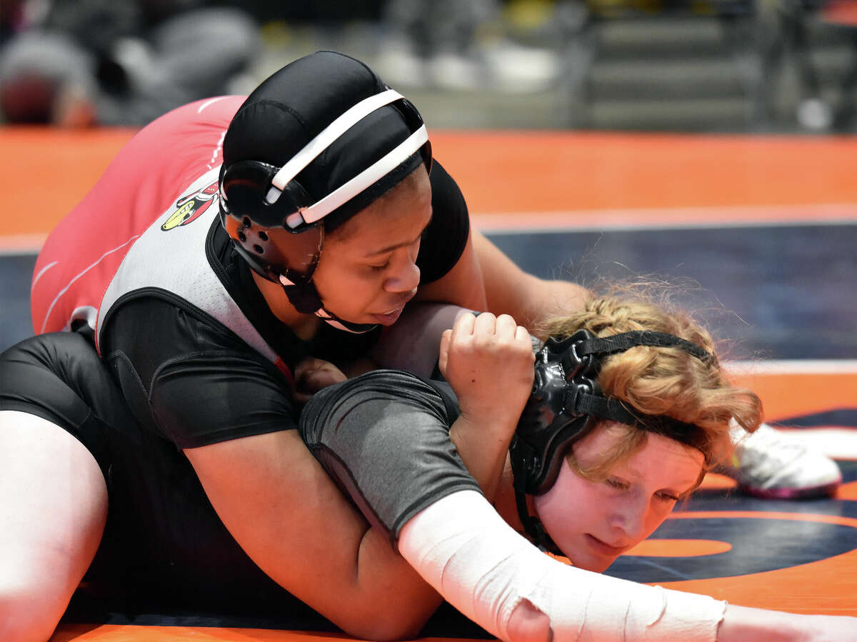 Antonia Phillips of Alton, top, wrestles Sajra Sulejmani of Lincolnshire Stevenson in the third-place match  of the 145-pound weight Class Saturday at the IHSA Girls State Wrestling Tournament in Bloomington. Phillips pinned Sulejmani in 1:26.