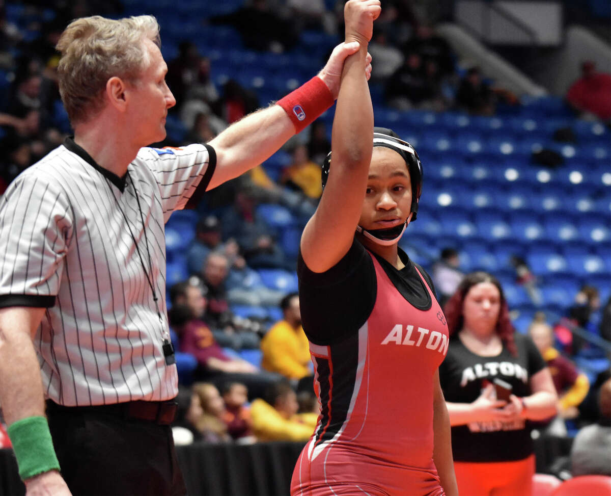 Alton's Antonia Phillips has her arm rasied by the mat referee following her pin of Sajra Sulejmani of Lincolnshire Stevenson in the third-place match of the 145-pound weight Class at the IHSA Girls State Wrestling Tournament in Bloomington.