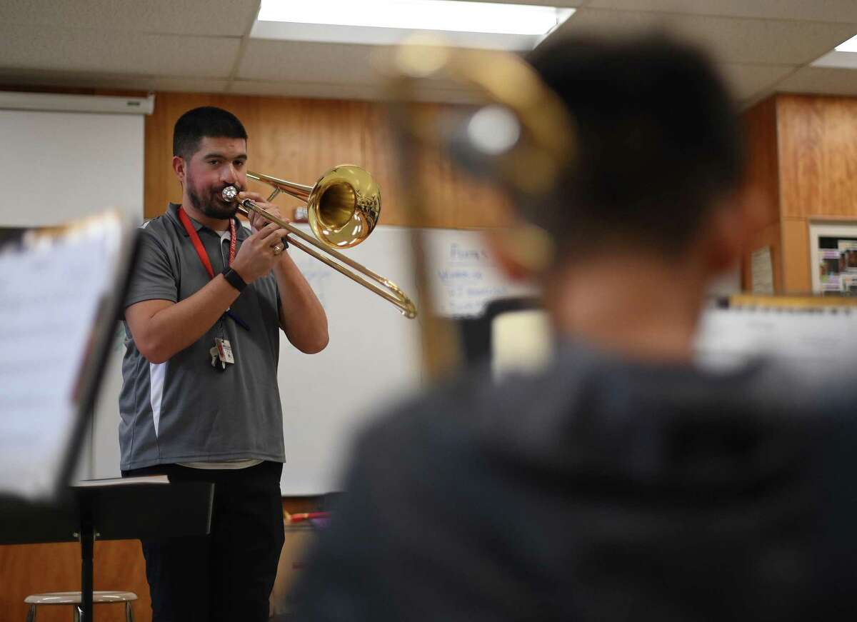 Adam Chitta is assistant band director at Wood Middle School. He works with trombone students on Thursday, Feb. 16. He wears hearing aids.