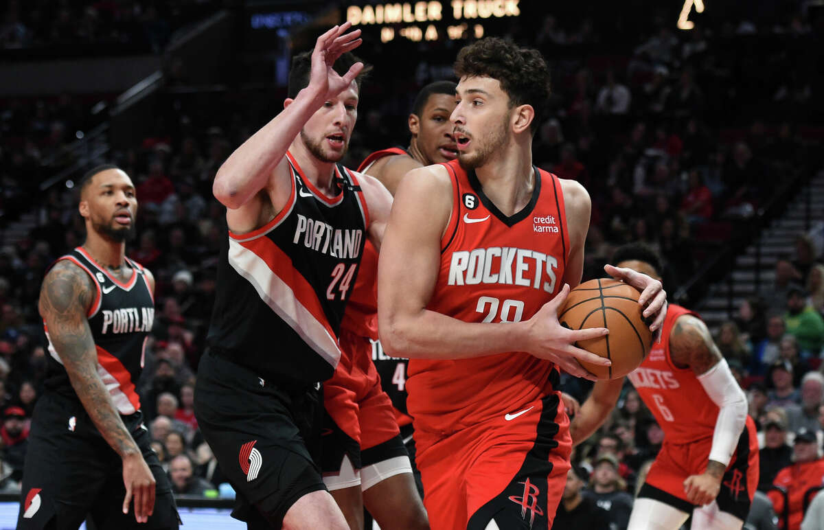 Houston Rockets center Alperen Sengun, right, looks to pass the ball as Portland Trail Blazers forward Drew Eubanks, left, defends during the first half of an NBA basketball game in Portland, Ore., Sunday, Feb. 26, 2023. (AP Photo/Steve Dykes)