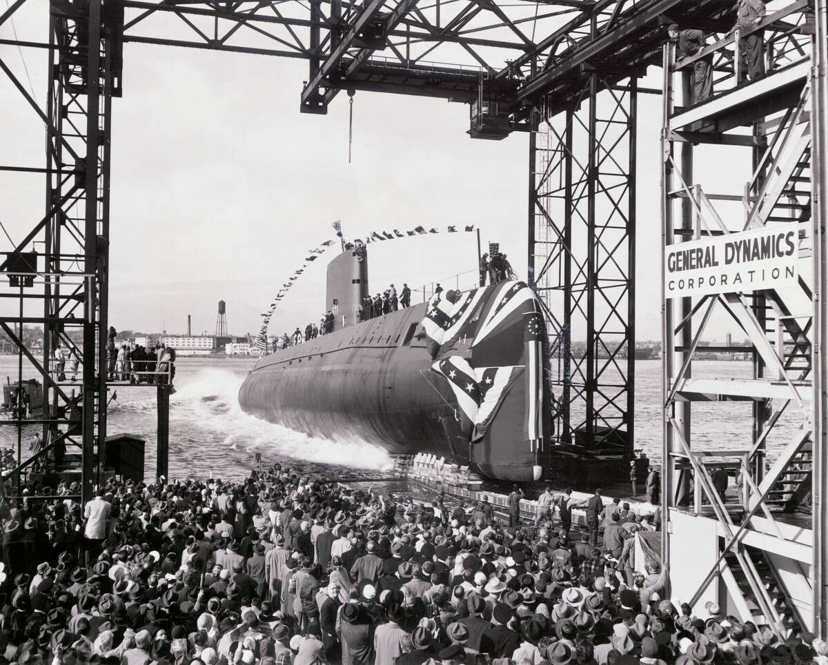 (Original Caption) The world's first nuclear powered submarine, the U.S.S. Nautilus, enters the waters of the Thames River at her launching here from shipyard of Electric Boat Division of General Dynamics Corporation, January 21, 1954. Vessel was christened by Mrs. Dwight D. Eisenhower, wife of the president. (Photo by George Rinhart/Corbis via Getty Images)