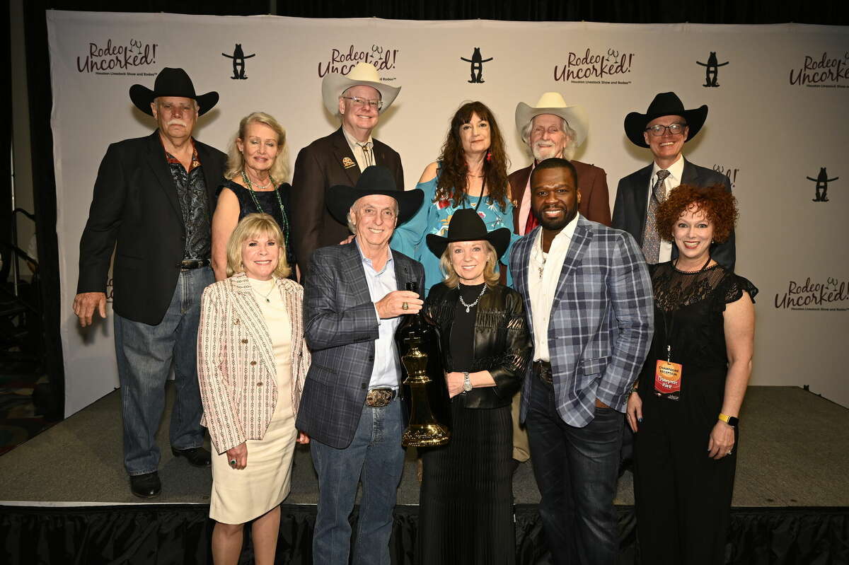 Owners and staff of J. Alan Kent Development pose with rapper 50 Cent and a bottle of Le Chemin du Roi Brut at the Houston Rodeo. The champagne, one of the champagnes produced under the rapper's wine label Sire Spirits, won the grand prize best of show award.