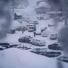 人们通过高山根据地的停车场在太浩栅栏冬季风暴星期五,2023年2月24日在高山草甸,加利福尼亚州加州和西部其它地区正面临着严重的雨雪从最新的冬季风暴磅美国。(美联社照片/约翰·洛克)