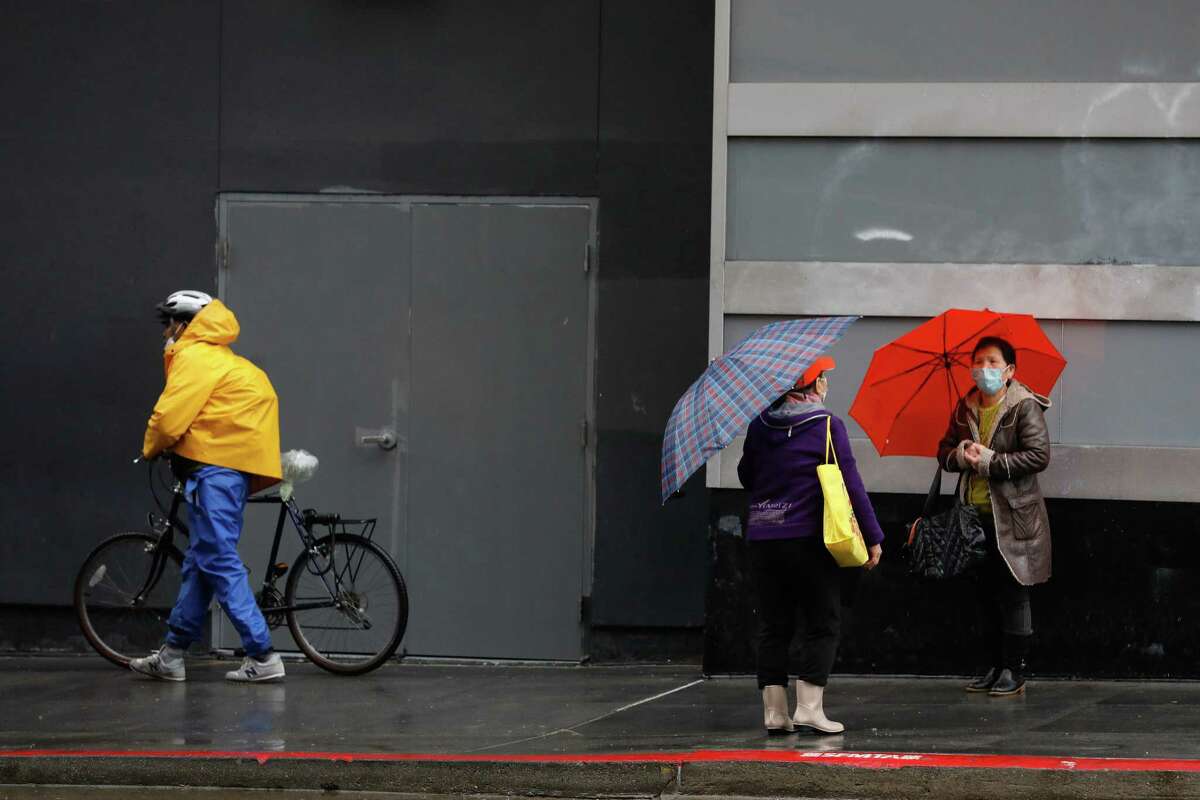 People use umbrellas and raincoats in San Francisco to keep dry on a day where periodic showers were mixed with sunny skies.
