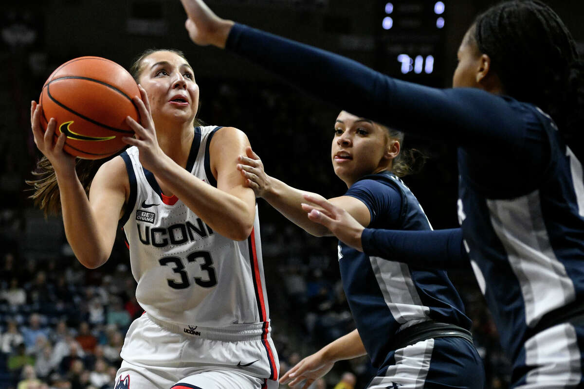 UConn's Caroline Ducharme, left, is guarded by Xavier's Shelby Calhoun, center, in the first half of an NCAA college basketball game, Monday, Feb. 27, 2023, in Storrs, Conn. (AP Photo/Jessica Hill)