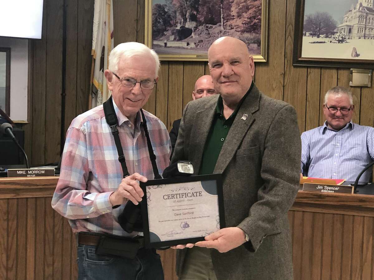 The city of Grafton's official city photographer Dave Sanford stands with Grafton Mayor Mike Morrow as he awards a certificate of recognition to Sanford for his work for the city.