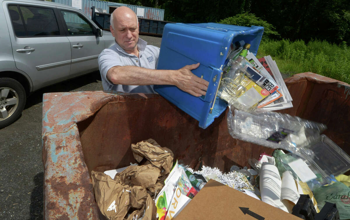 A town resident dumps recyclable materials at the Wilton Transfer Station on July 26, 2018.