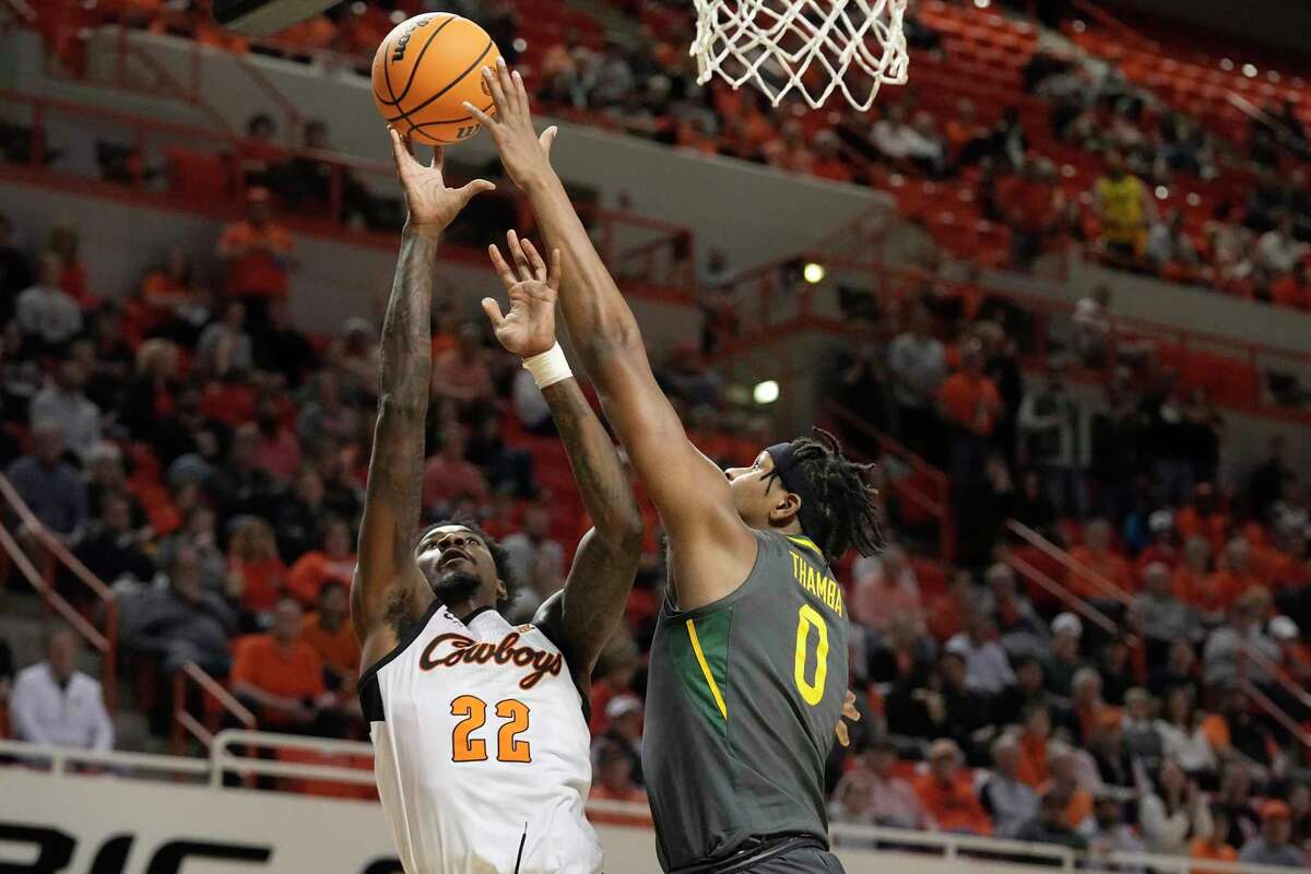 Oklahoma State forward Kalib Boone (22) shoots as Baylor forward Flo Thamba (0) defends in the first half of an NCAA college basketball game, Monday, Feb. 27, 2023, in Stillwater, Okla.