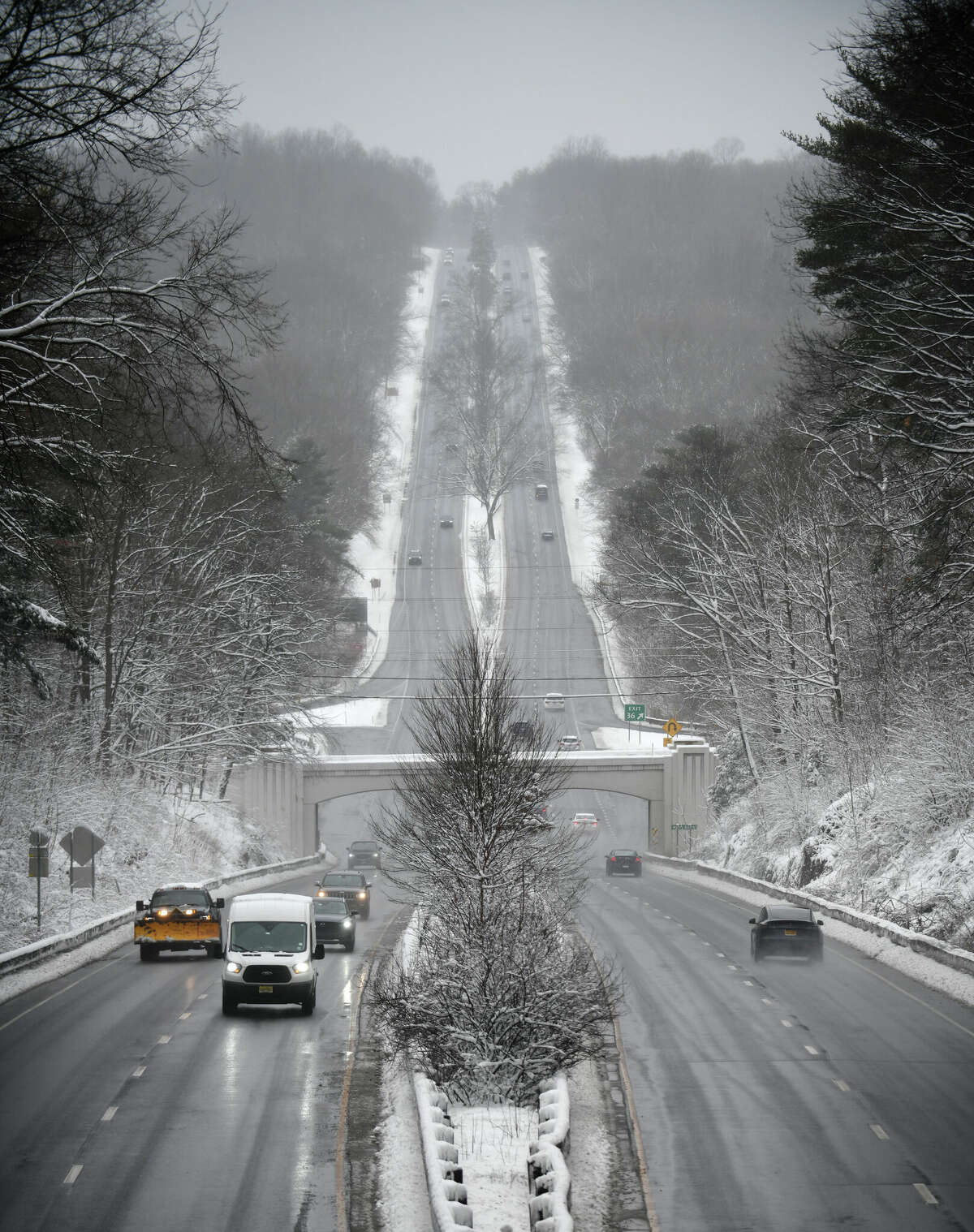 Traffic moves along the snowy Merritt Parkway near Exit 36 in New Canaan, Conn. Tuesday, Feb. 28, 2023. The area received its first measurable snow accumulation of the year, albeit just a few inches, from a storm Monday night through Tuesday morning.
