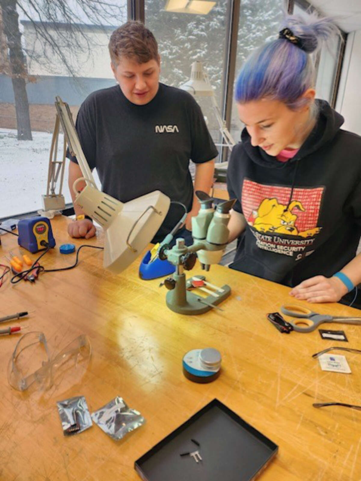 Abigail Peterson (right), a senior in Information Security and Intelligence from White Lake, works with Kyle Bowen (left) on research for Ferris State University's new course Satellites and space cybersecurity. 