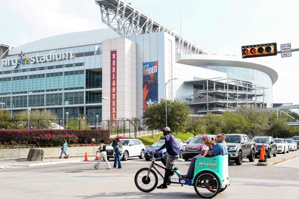 Visitors ride in a pedicab as they make their way into the NRG Park grounds for the opening day of the Houston Livestock Show & Rodeo on Tuesday, Feb. 28, 2023 in Houston.