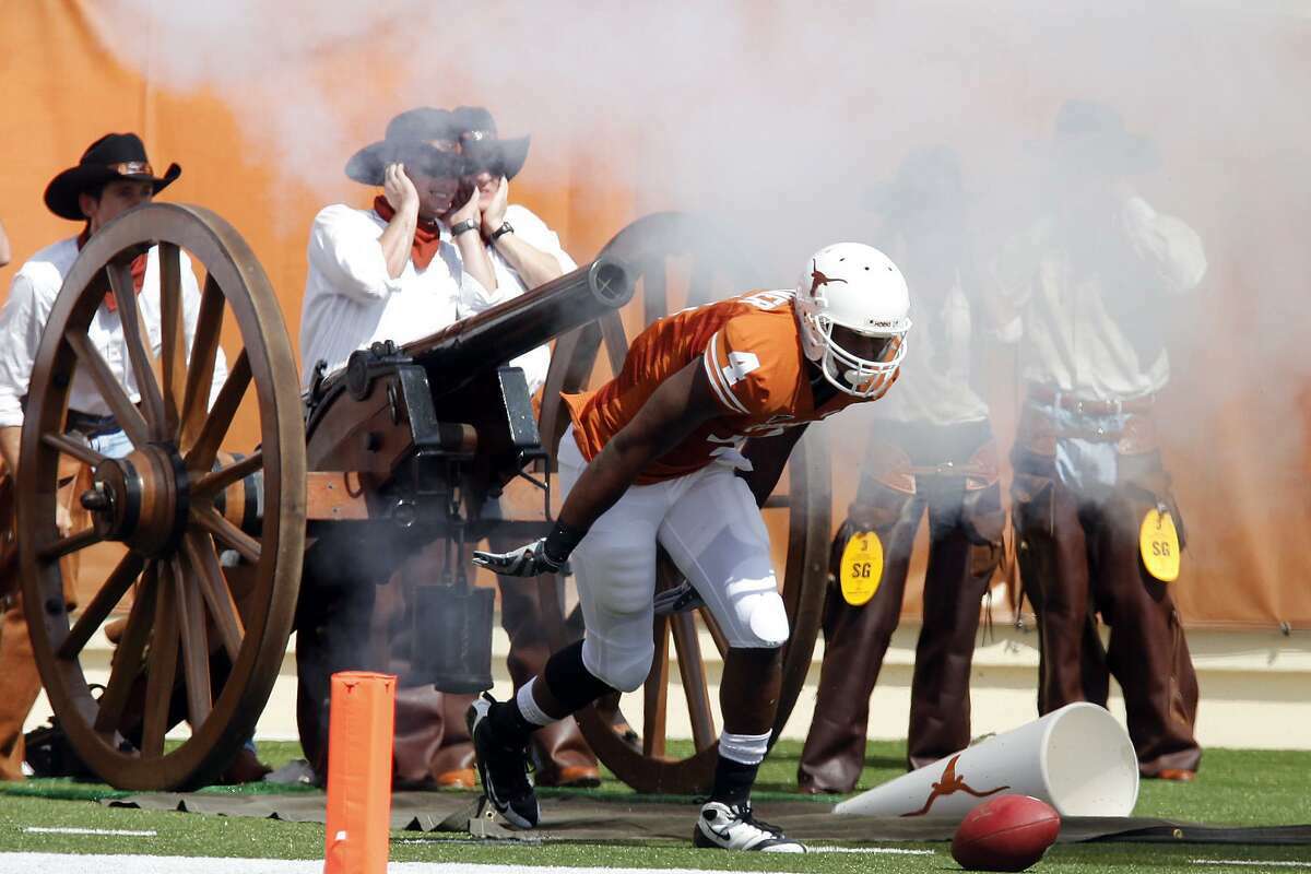 The Texas Cowboys fire off the University of Texas cannon after each touchdown. In this Sept. 26, 2009, file photo, UT Longhorns receiver Dan Buckner ducks his head as the cannon goes off right behind him after he scored a touchdown in the first half against the University of Texas El Paso.