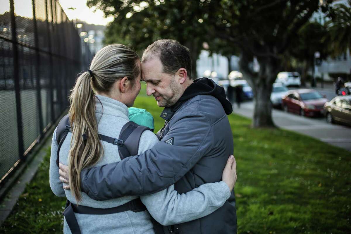 Matthew (right) embraces his wife and baby days after they were brutally attacked in the Mission District in San Francisco. Two 17-year-old girls were arrested on suspicion of committing the attack. 